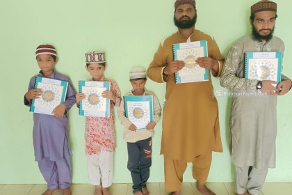 9. Students and teachers holding Al Fitrah's braille Primers delivered to them by Rahman Foundation